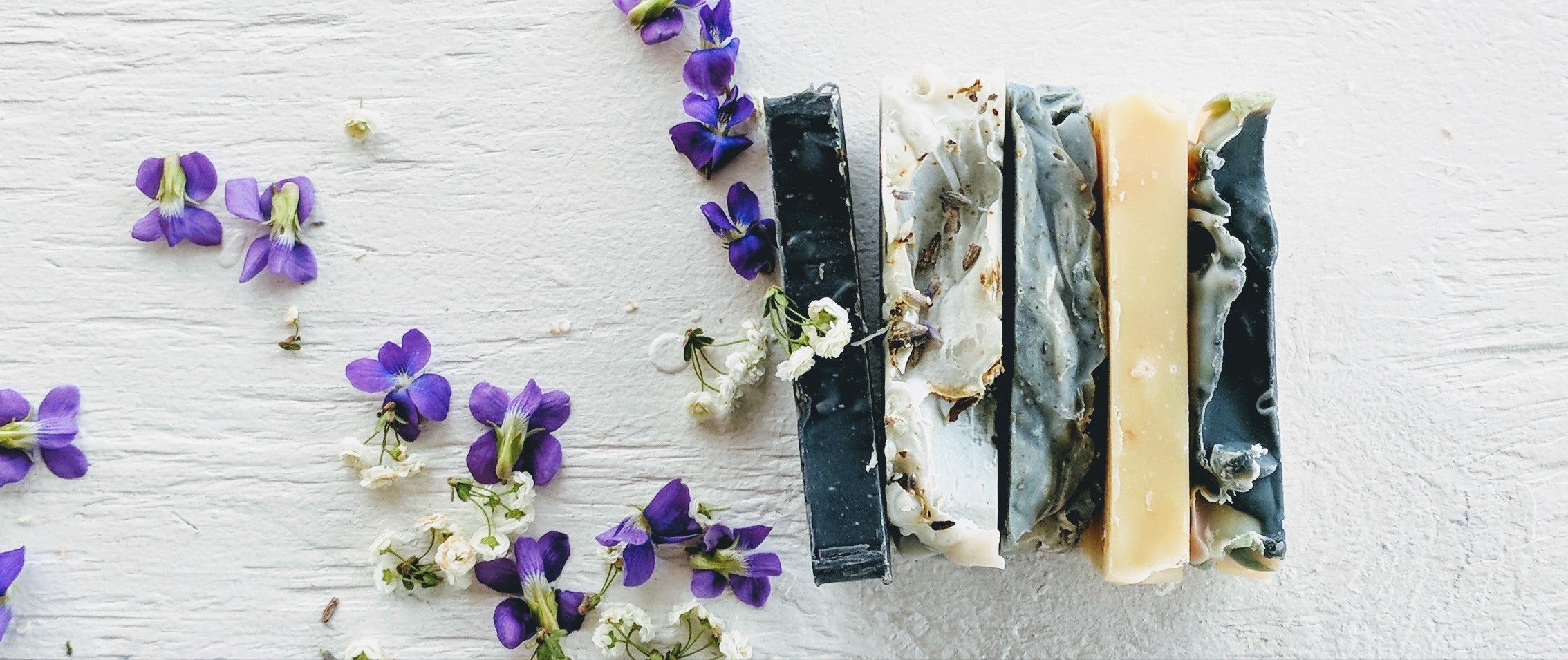 Several Lovesfield handmade soap bars 5oz each, palm-free, handcrafted in North Carolina, showing variety of scents and packaging